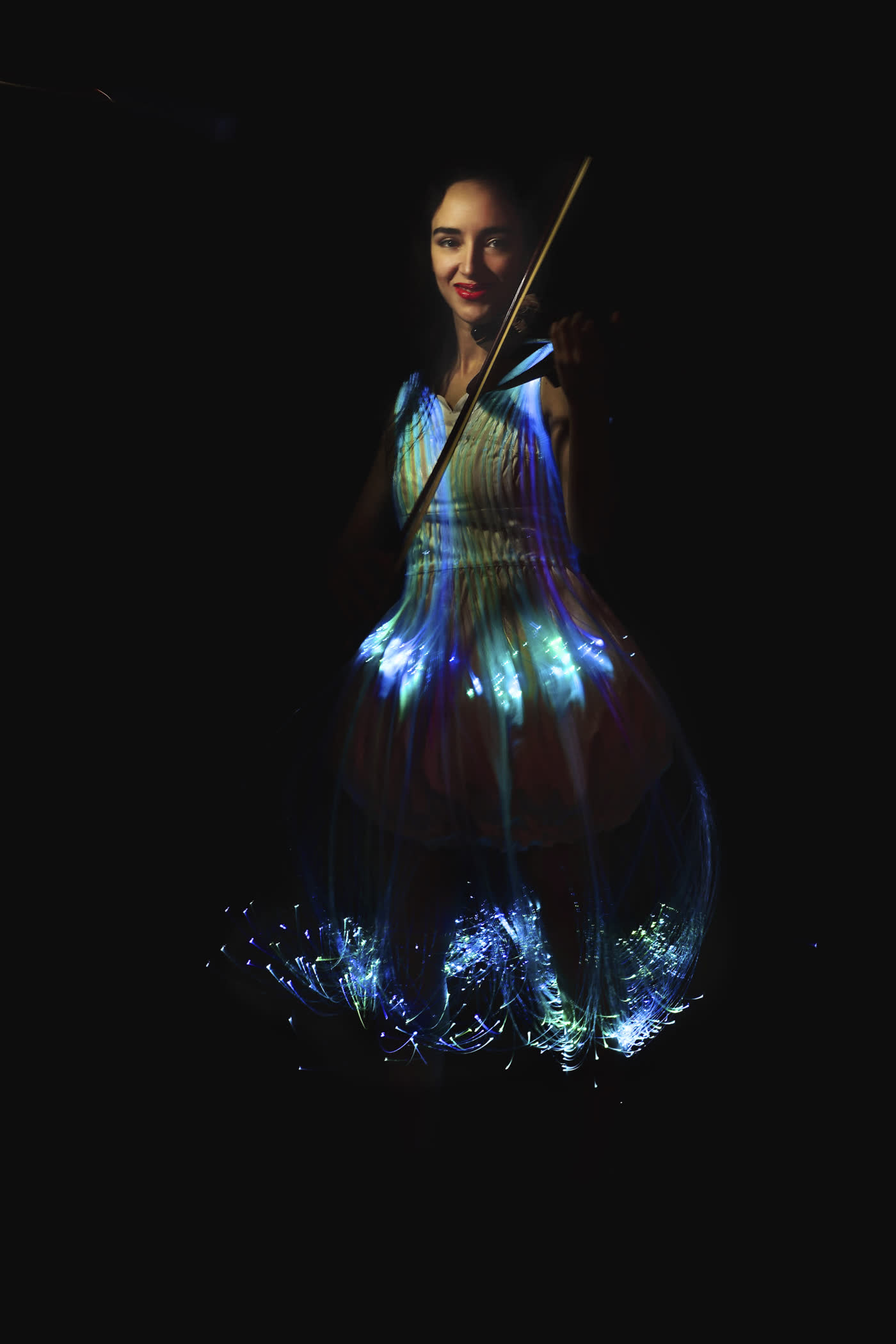 The couture light dress glowing blue-white in darkness