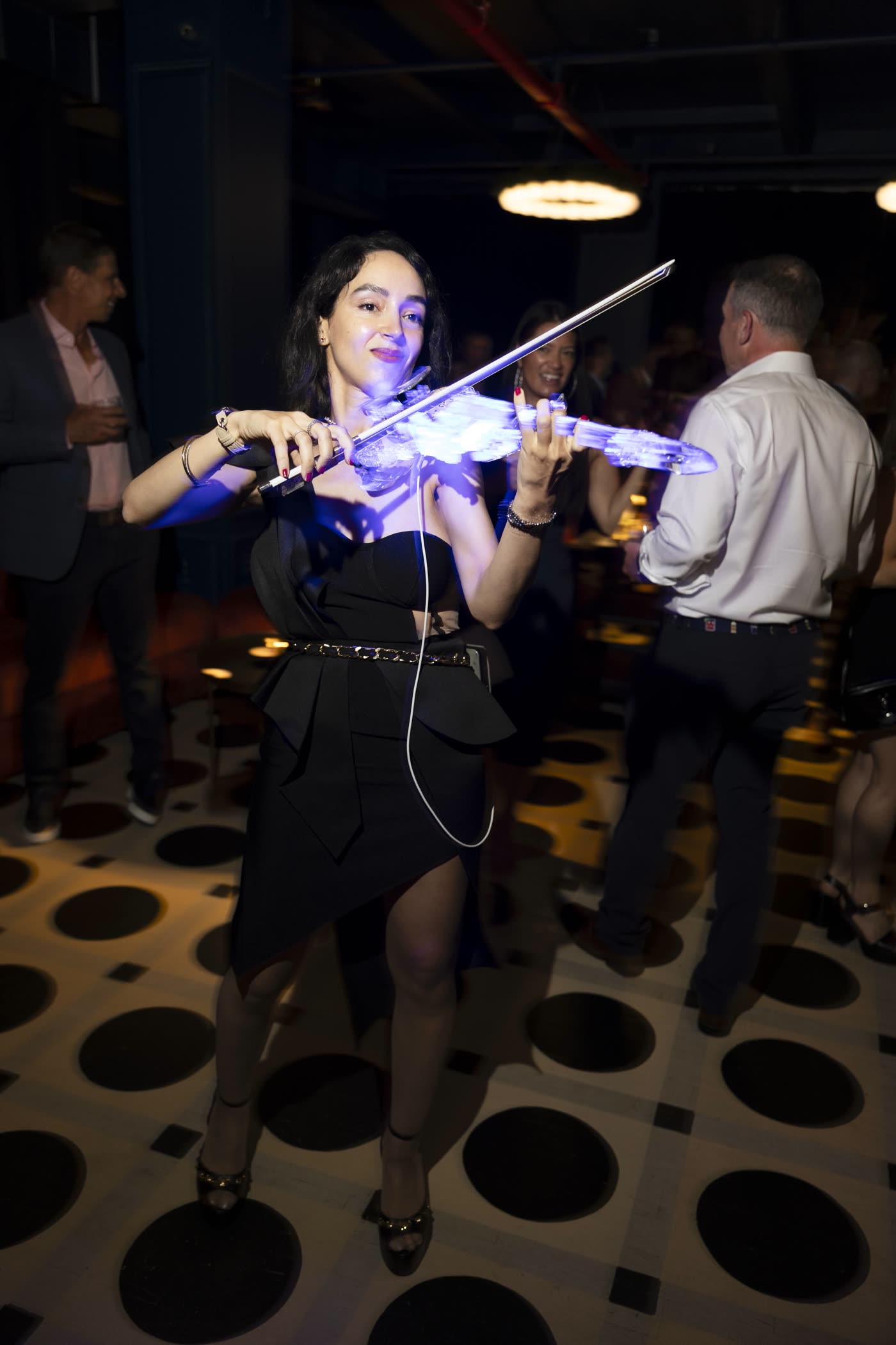 Guests watching Sadie play the lit transparent violin