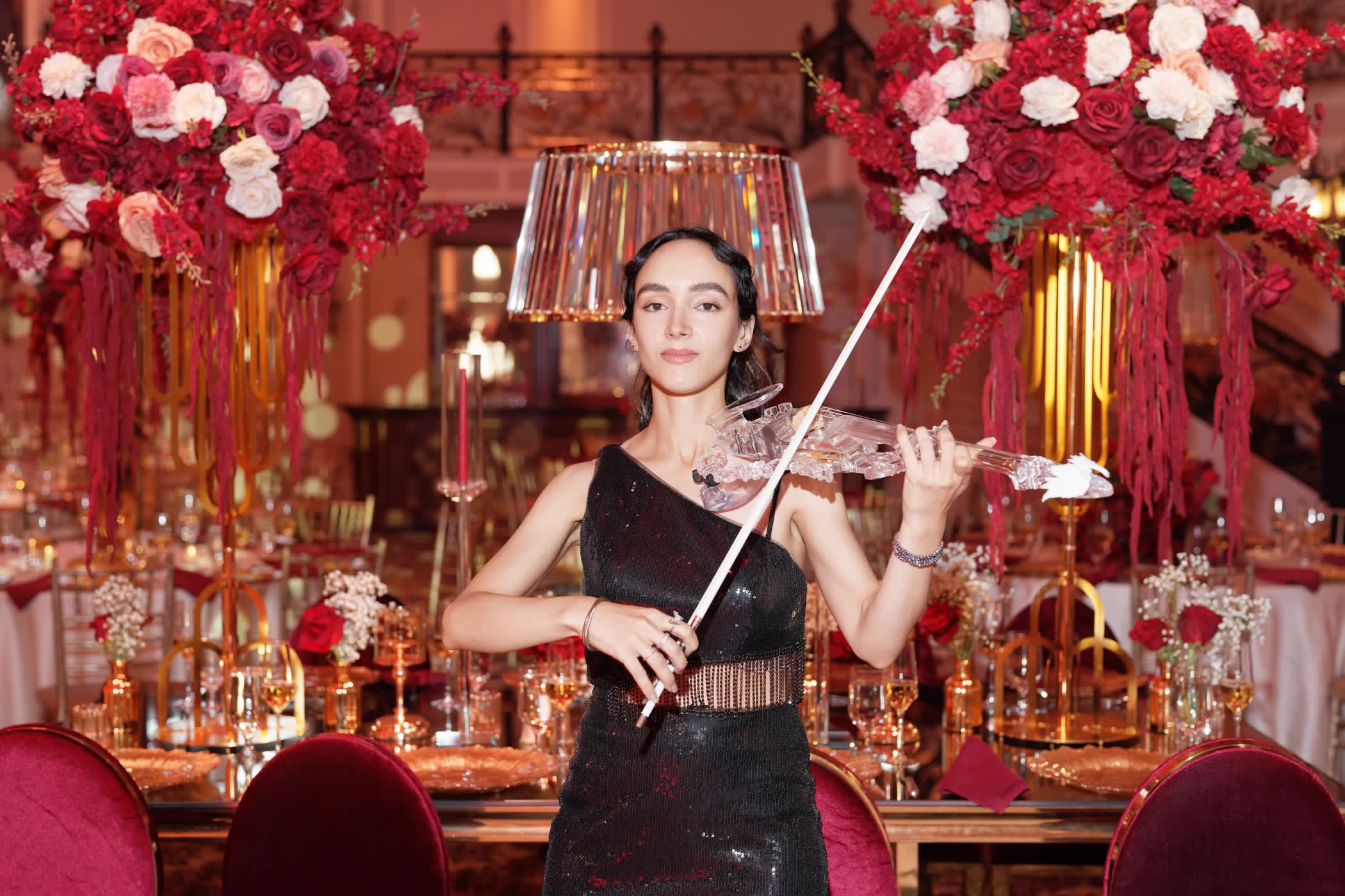 The transparent violin held out in close-up, every line of the custom body visible