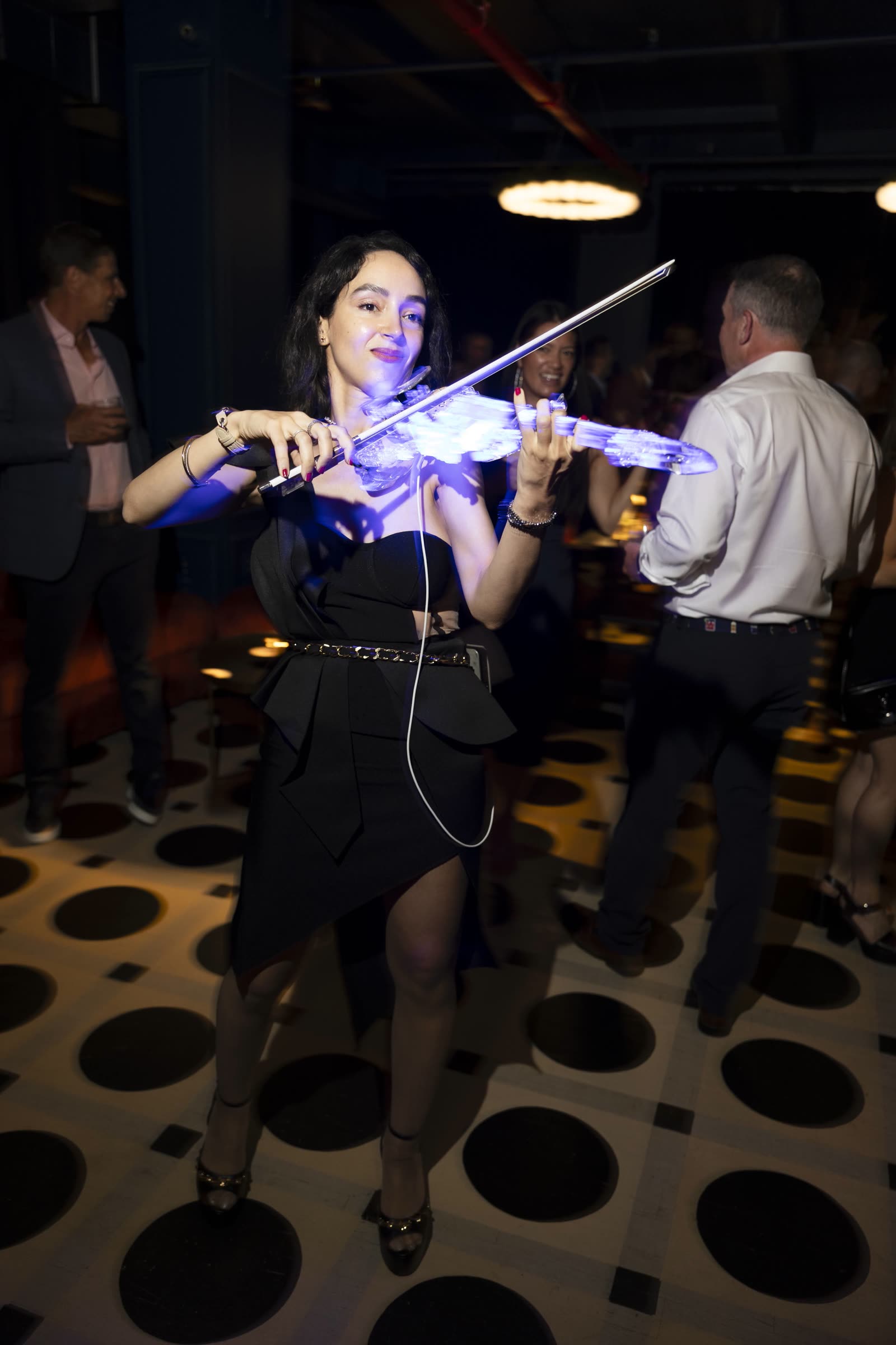 Sadie playing the transparent violin over a crowd, electric show
